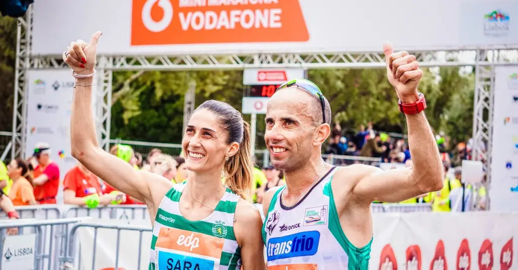 Close-up of amateur runners on a flat riverside road in Lisbon during a half marathon, motion blur, crowd of participants, morning light, colorful running bibs, photorealistic stock photo