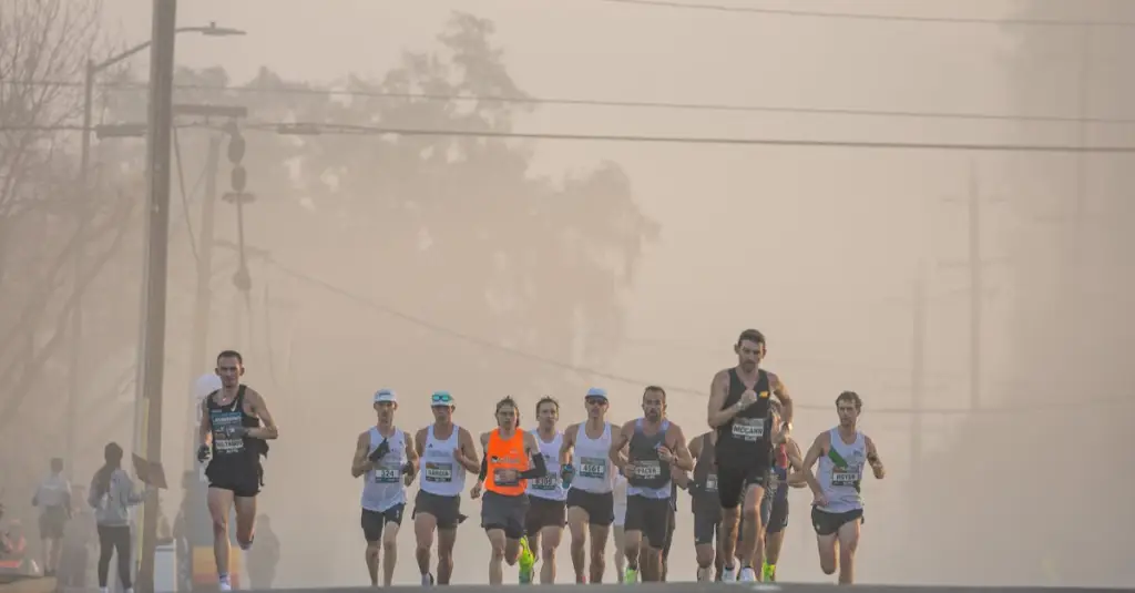 A group of recreational runners of different ages and fitness levels running together on a riverside road in Lisbon, morning light, motion blur on legs, photorealistic stock photo