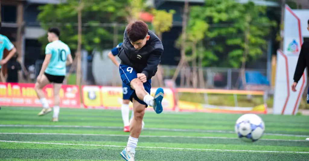 Football player in full sprint during a competitive match, motion blur, stadium atmosphere, focus on athleticism and speed, photorealistic sports photography