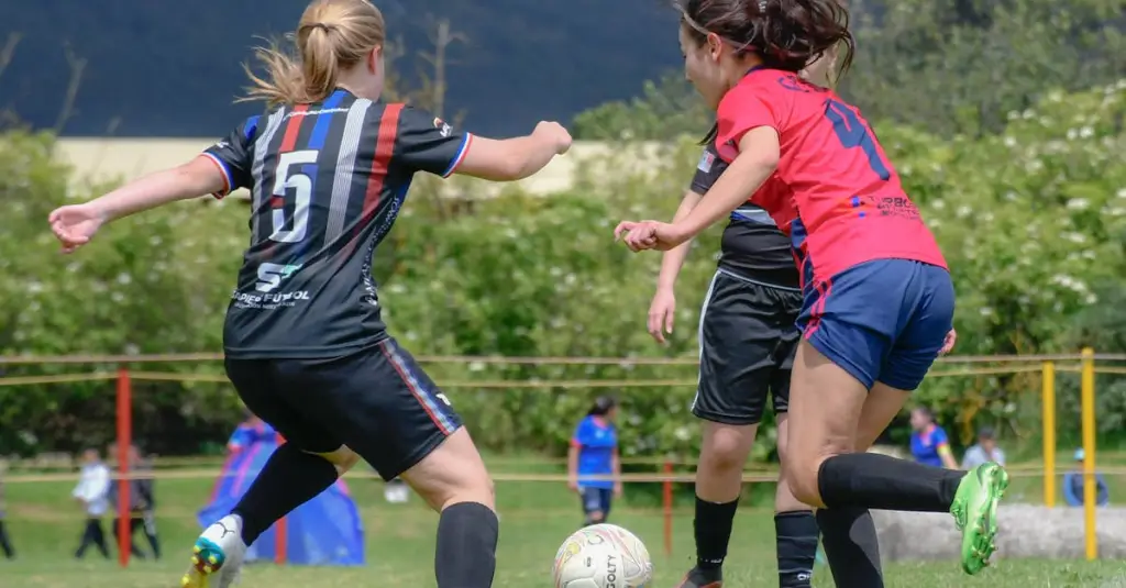 A female soccer forward sprinting at full speed during a match, motion blur on the background, stadium crowd, professional sports photography, golden hour lighting