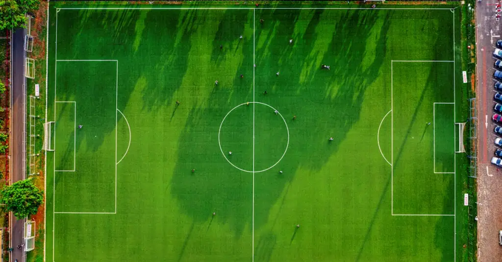 Aerial view of a football match with players in different field positions highlighted, tactical overview, realistic sports photography, top-down perspective of a full football pitch